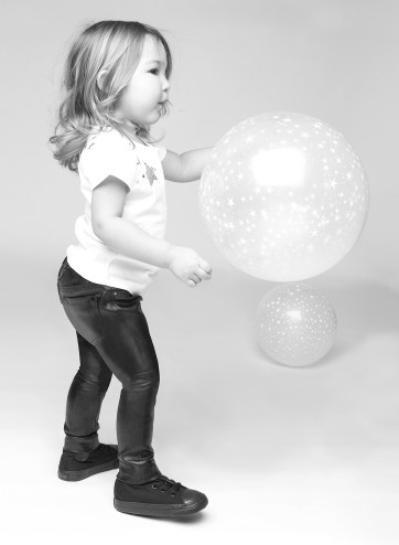 niña con pantalones de cuero negro y camisea blanca junto a una bola de luz de Chalk,  colección otoño-invienro 2013 en Chulakids